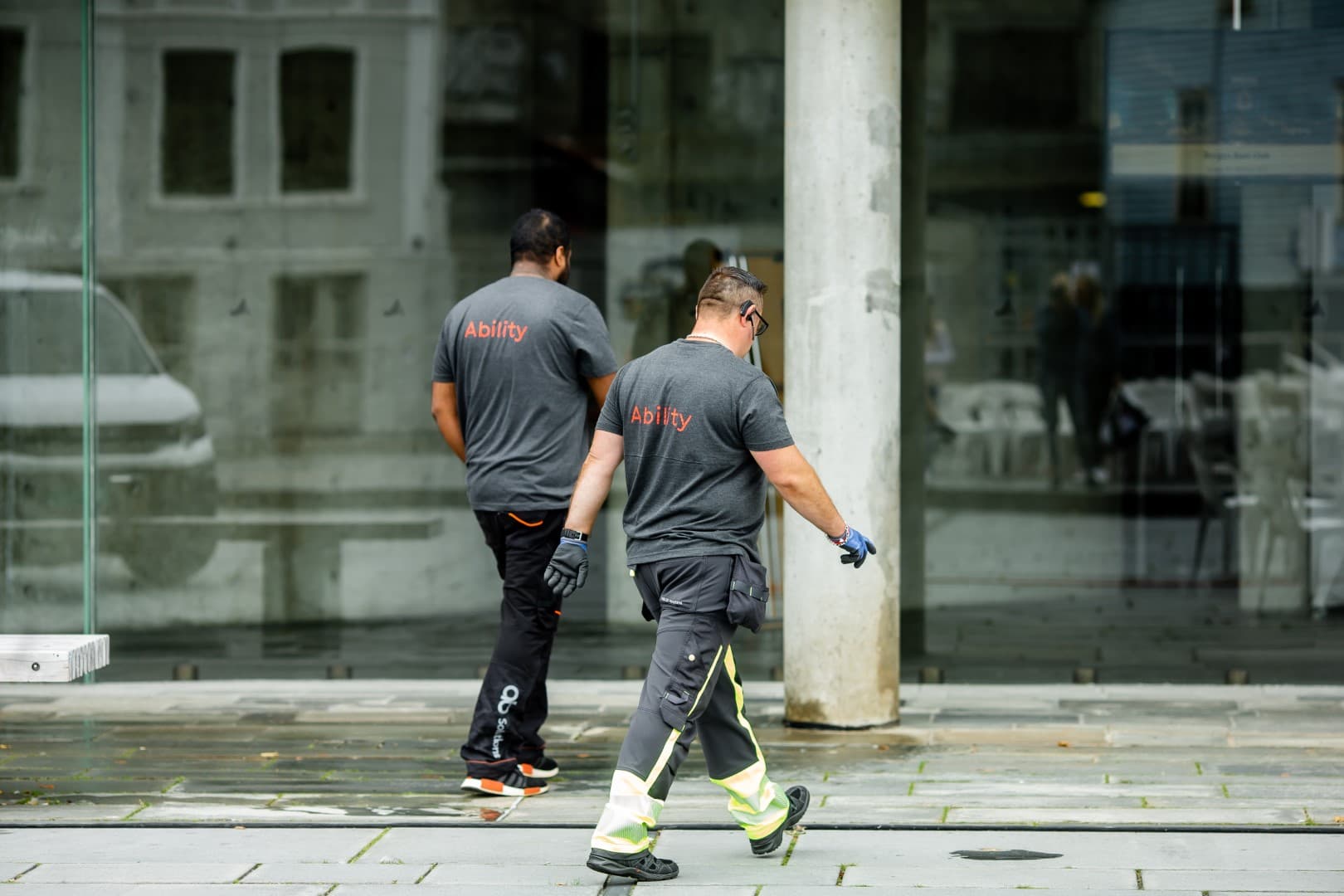 Two Ability employees on their rounds outside a commercial building