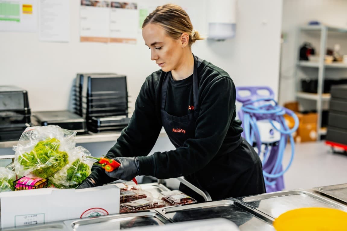 Ability employee preparing fresh produce in the kitchen