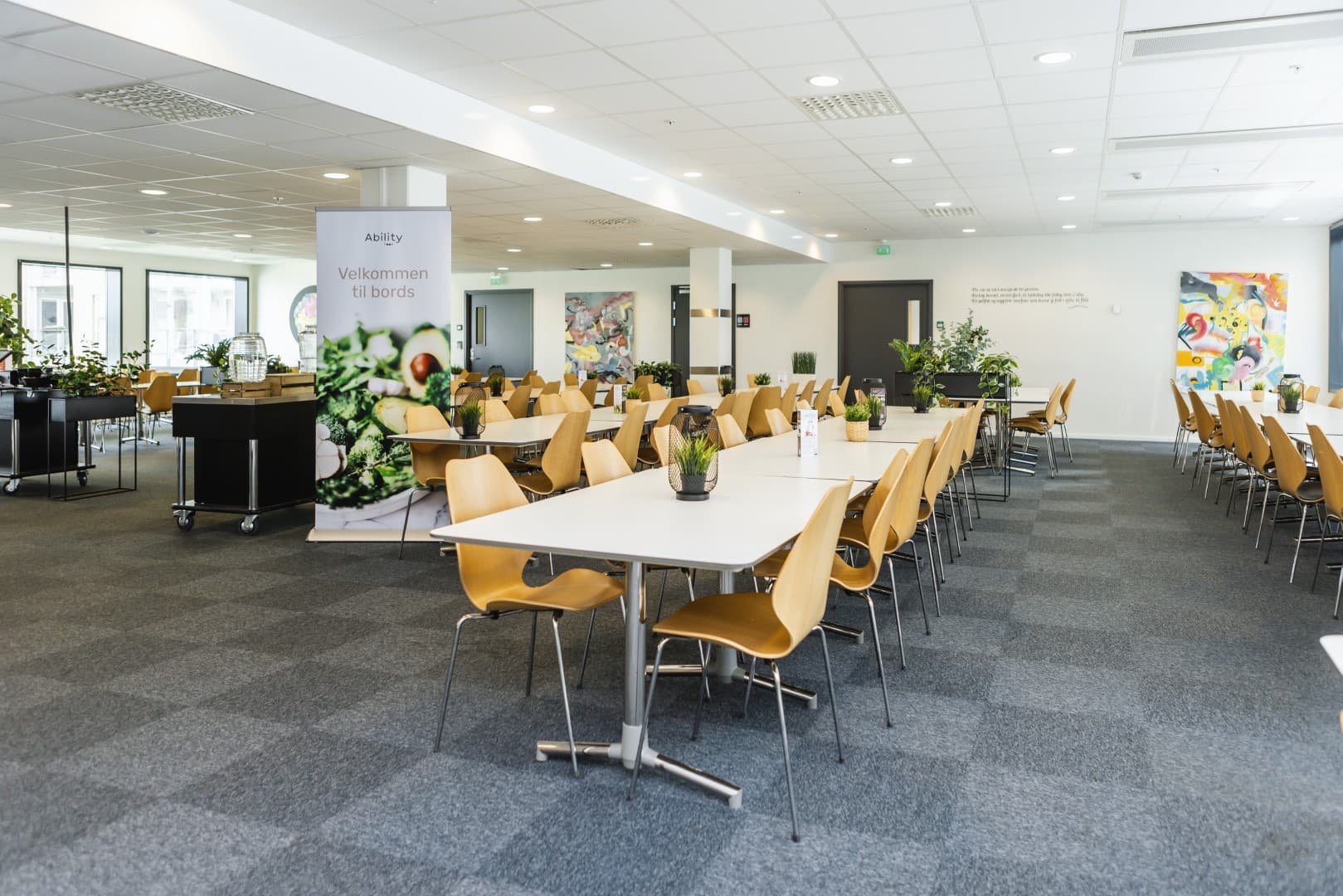 Canteen hall set for lunch, with Ability's welcome banner