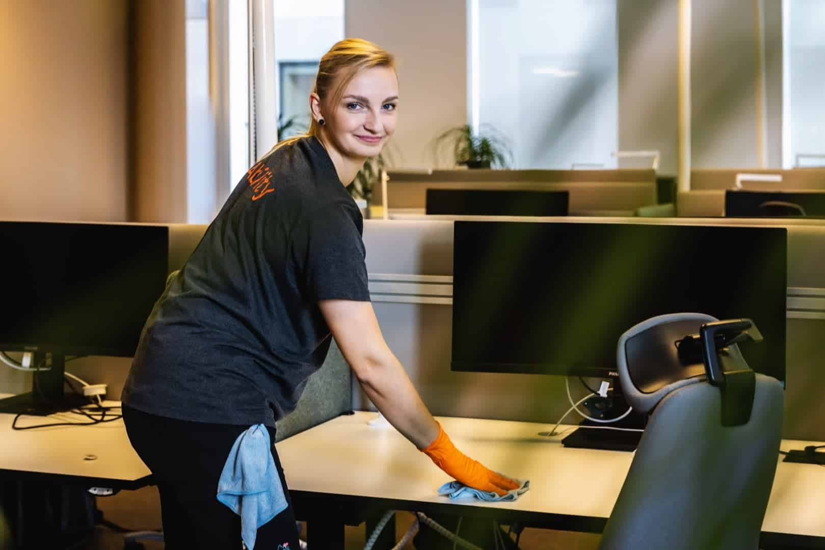 Ability cleaner wiping an office desk with a microfibre cloth