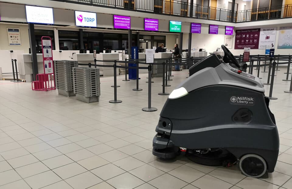 Autonomous floor-scrubbing robot at work in an airport terminal