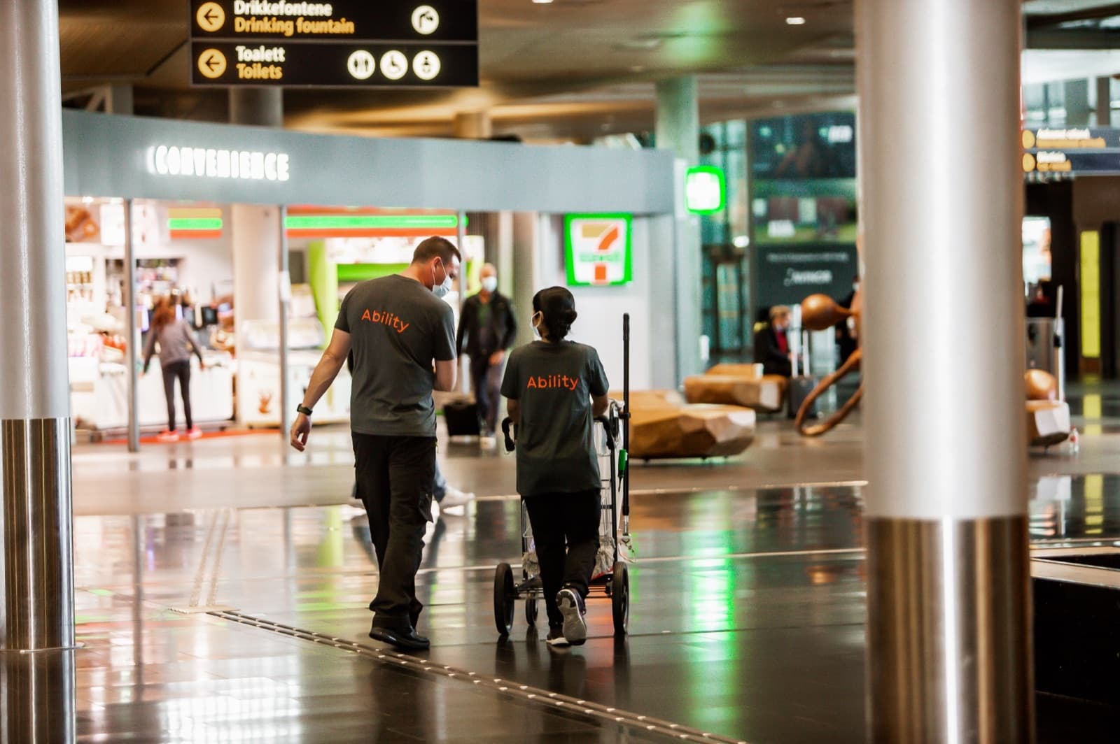 To renholdere fra Ability i arbeid i en flyplassterminal